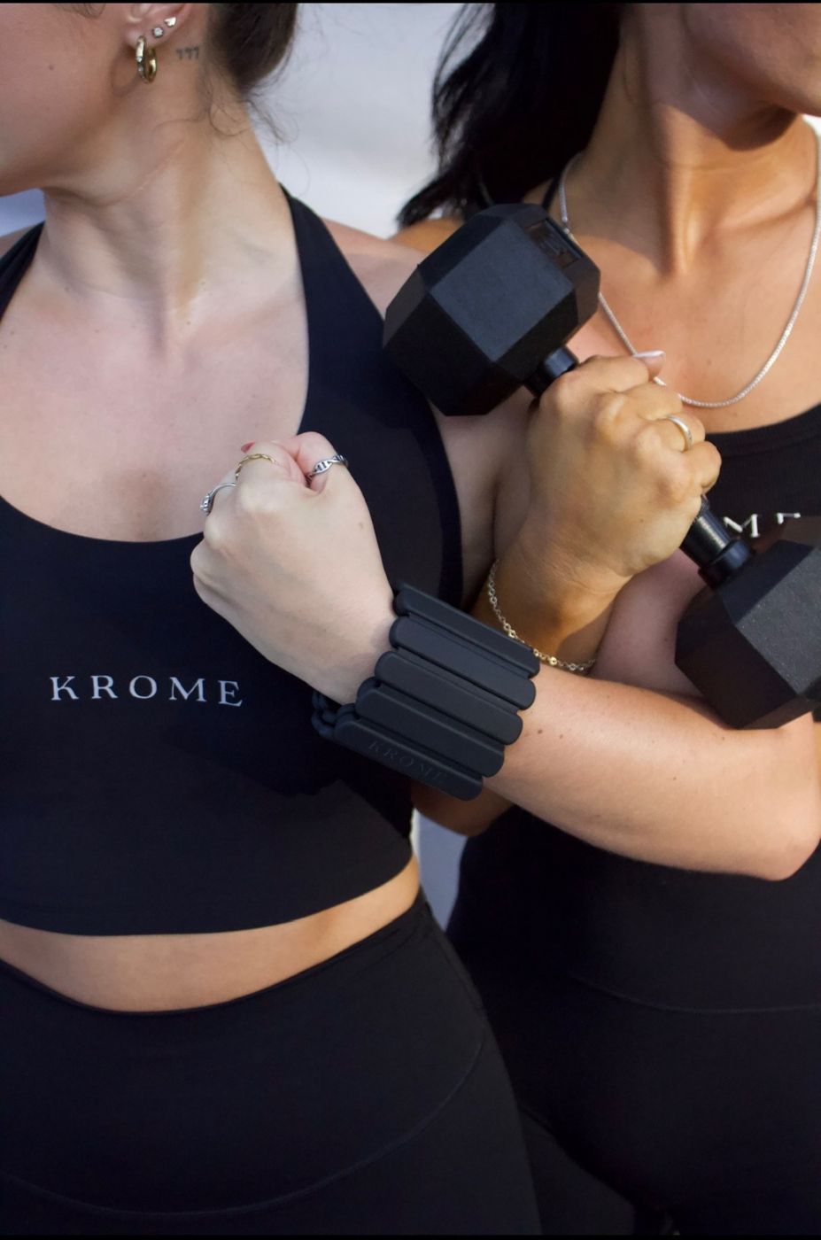 Two women in Krome tops holding a dumbbell and wearing wrist weights